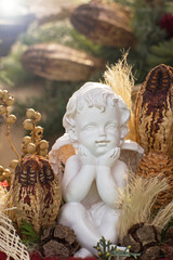 Obraz premium Small white angel statue rests in a display of natural decorations in a cozy setting during the afternoon