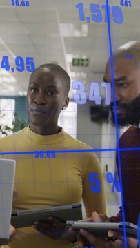 Vertical video: Team responding to blue charts animating, reviewing business data on PC for insight