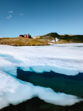 Frozen lake in mountains landscape in Norway wilderness nature melting ice and water scenery travel scandinavian beautiful destinations in Lahko national park