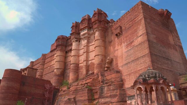 A low-angle static shot of the massive defensive walls and soaring palace structures of Mehrangarh Fort, showcasing grand Rajput military architecture in Jodhpur, Rajasthan, India