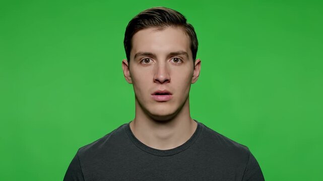 Startled Expression: A young person displays an expression of awe and disbelief, captured against a vibrant green backdrop.
