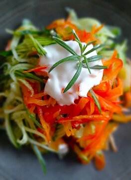 Fresh made vegetable salad with carrot, cucumber , peppers and fresh rosemary herb and yogurt sauce
