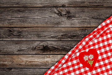 Fototapeta premium Checkered table cloth with a heart design and floral pattern on wooden surface in a kitchen setting