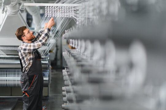 Factory worker adjusting polypropylene yarn production line