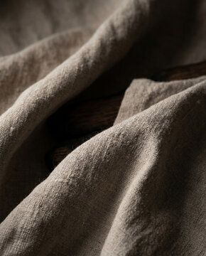 Macro study of high-density heavy linen folds. The lighting reveals the intricate weave and organic slubs of the premium textile, evoking a sense of sustainable luxury and tactile depth.
