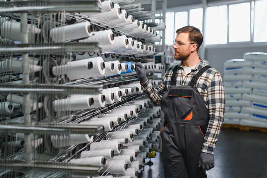 Worker controlling polypropylene thread spools in a textile factory
