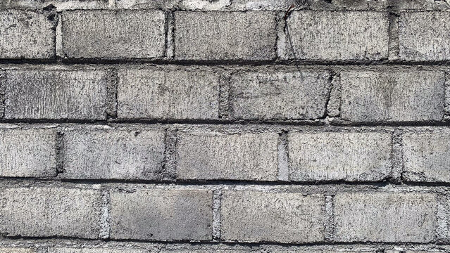 ​Grungy grey concrete block wall texture background, weathered cinder block brickwork surface with cement joints