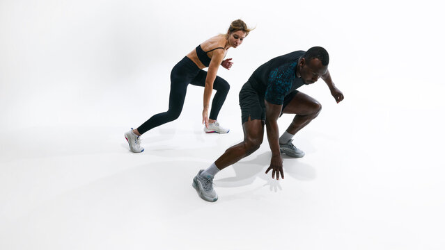 Fit couple performing beep test shuttle sprint exercise for endurance assessment. Concept of beep test training, cardio endurance measurement, agility workout, performance evaluation