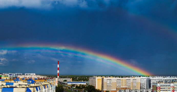 Fantastic beautiful rainbow over city buildings after rain