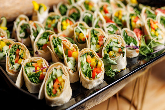 Healthy vegetable wrap slices with colorful peppers and greens on a platter