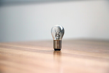 Brilliant idea concept with a light bulb standing upright on a wooden surface. Creative thinking, innovation, and idea concept © Acento Creativo