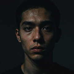 Obraz premium Moody portrait of a young man with intense expression and dark background