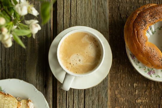 Cup of coffee and pastries on a rustic wooden table. Overhead shot. Morning breakfast, coffee break. Everyday routine.