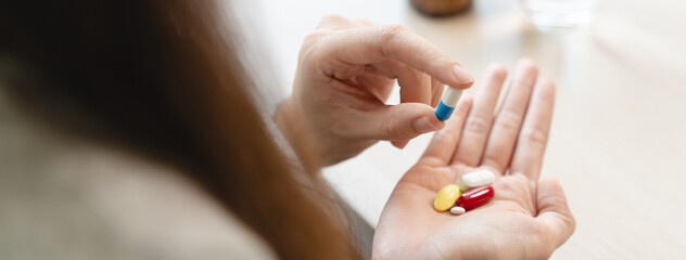 Healthcare Harmony: Close-Up Hands Holding Medication and Water Glass for Optimal Wellness,...