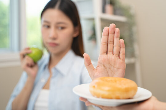 Diet food loss weight concept, Hand of woman pushing sweet away and avoid to eat fried chicken to control cholesterol and sugar.