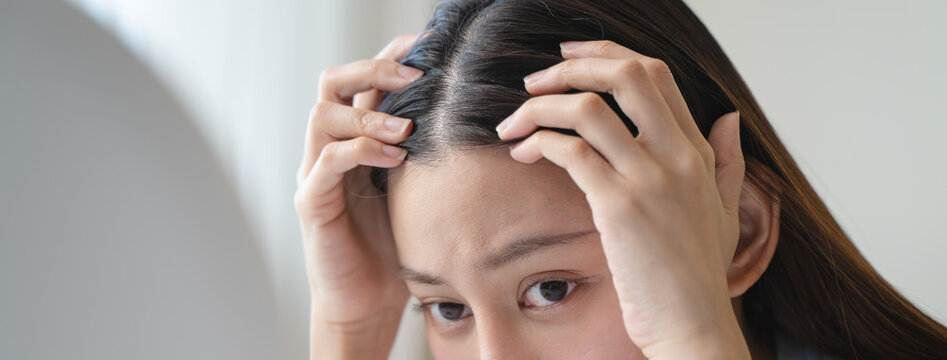 Young woman worrying about her thin hair and hair fall