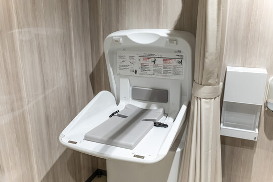 多目的トイレに設置された開閉式のおむつ交換台とプライバシー保護用のカーテン
