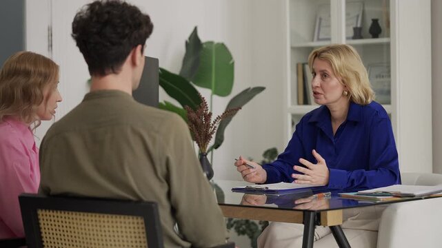Woman travel agent consulting young couple about insurance and legal services