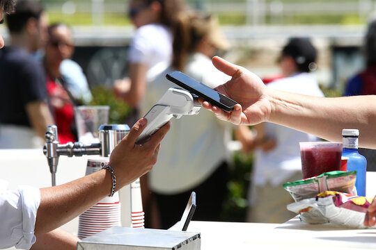 Pagar con tel&eacute;fono en dat&aacute;fono tpv en compra con cartera m&oacute;vil y pago de billetera digital en comercio y camarero de hosteler&iacute;a y restauraci&oacute;n cobrando al aire libre
