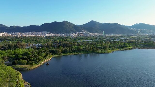 Serene aerial view of a tranquil lake and lush green landscape with distant mountains