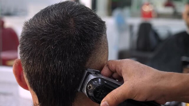 Close-up of electric clipper cutting hair. The scene focuses on fade technique, precision, and the modern approach to male grooming.