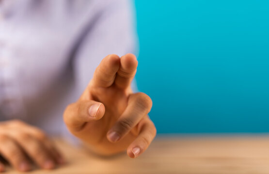 Close-up of a hand with a gesture of pointing or touching a screen with blurred background.