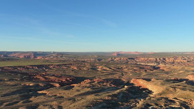 This aerial perspective showcases the vast scale of Grand Staircase-Escalante. Vibrant seasonal greenery blankets the desert floor amidst the towering Utah mesas.