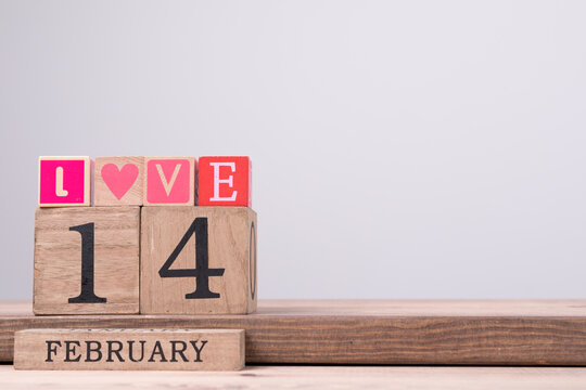 Wooden blocks spell out Love with February 14 date for romance celebration.