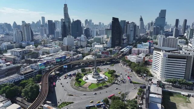 Victory Monument roundabout shows vehicles circulating around the central obelisk with dense urban buildings nearby.