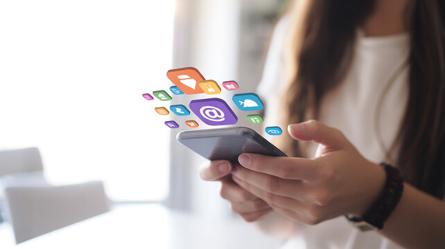 Person holding smartphone with social media icons floating above