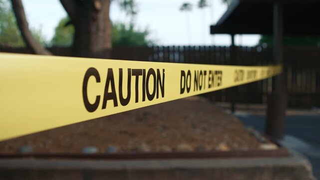 Yellow caution tape do not enter in perspective along unsafe restricted zone daytime shows restricted access area safety and perimeter control in outdoor environment
