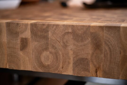 Close-up of a textured oak wood butcher block surface with visible grain patterns and rings