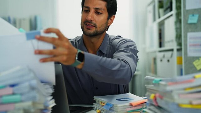 Hispanic manager indoors, frustrated by multitasking and paperwork, showing burnout and disappointment.