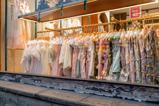 Suzhou, China, 31 March 2026 ? Traditional Chinese Hanfu garments in pastel colors hang on golden racks in a boutique shop window display during spring.