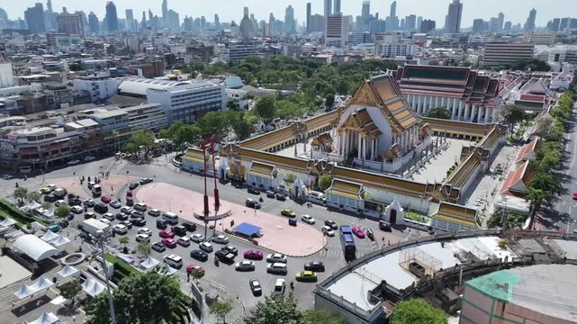 The red GiantSwing and wat suthat thepwararam temple appear within active city streets, historic architecture and movement around.