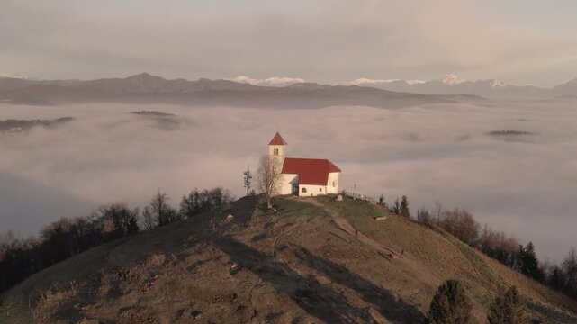 Drone Sunrise View of Sv Ana Church Above Fog, Slovenia