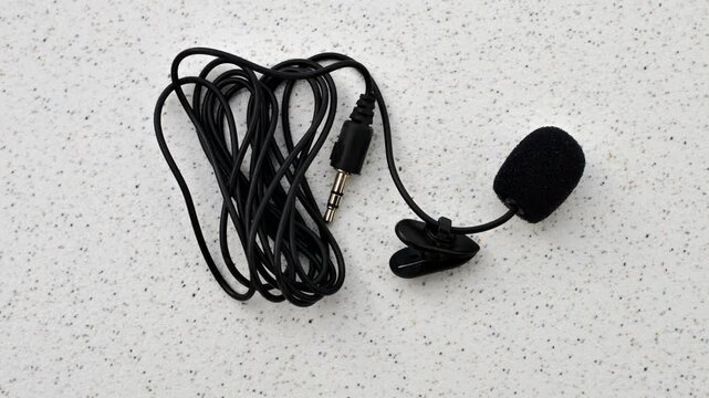 Close-up of lavalier microphone on smooth surface, ready to capture audio with elegance and precision.
