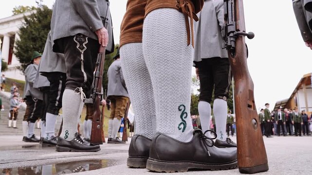M&auml;nner in Tracht mit Lederhose und Haferlschuhen laufen auf dem Oktoberfest