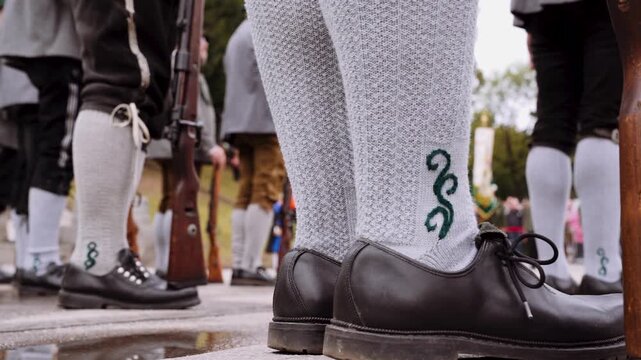 M&auml;nner in Tracht mit Lederhose und Haferlschuhen laufen auf dem Oktoberfest
