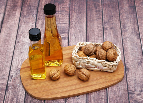 High-quality walnut oil in glass bottles with whole walnuts on a wooden board.