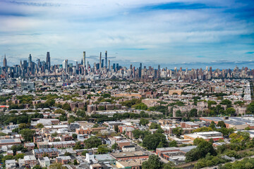 Fototapeta premium Aerial view of Manhattan midtown highlighting the tall slender Billionaires Row skyscrapers. Queens and Long Island City are in the foreground with many low rise buildings and trees.