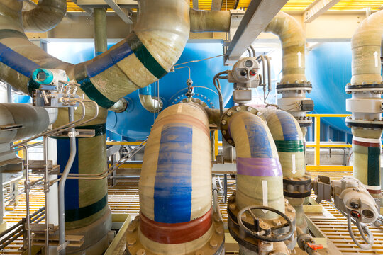 A complex array of large industrial pipes and control valves installed at a water desalination plant in Chile, South America.