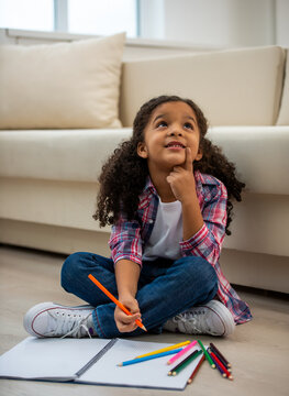 Girl thinking while drawing at home.