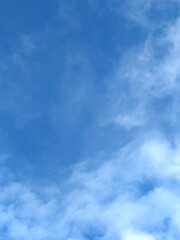 Fototapeta premium Moody white clouds across a blue black sky change in weather skyscape