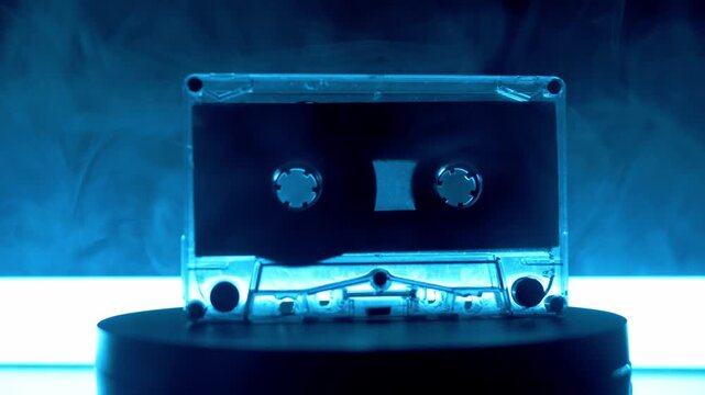 A transparent audio cassette tape spins on a turntable surrounded by swirling smoke and shifting neon lights. Concept of retro music, eighties nostalgia, and synthwave aesthetics.