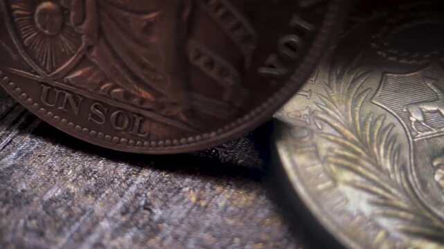 Close up video of a Peruvian un sol coin collection featuring antique silver surfaces, engraved details, and classic historical design elements.