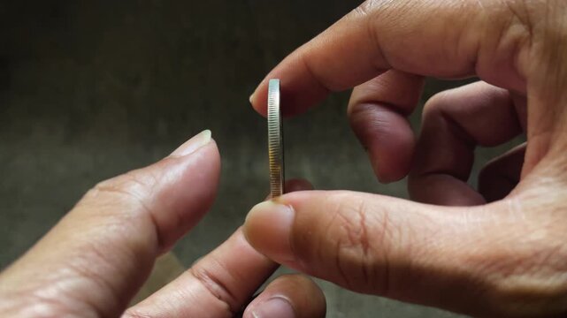 Close up video of hands examining an antique Peruvian Un Sol silver coin, highlighting the seated Liberty figure, engraved lettering, and historical relief details.