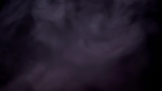 Thick clouds of violet vapor swirl and dissipate into the darkness of a black void. Concept of magic spells, mysterious atmosphere, aromatherapy, and abstract flowing motion.