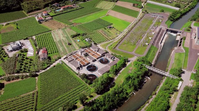 Water purification plant with settling tanks near Sarca River, aerial view. Engineering infrastructure for wastewater treatment