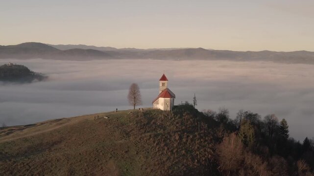 Drone Sunrise View of Sv Ana Church Above Fog, Slovenia
